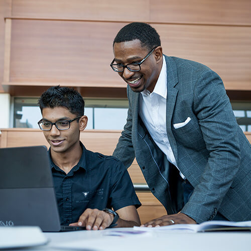 Faculty member and student looking at a computer